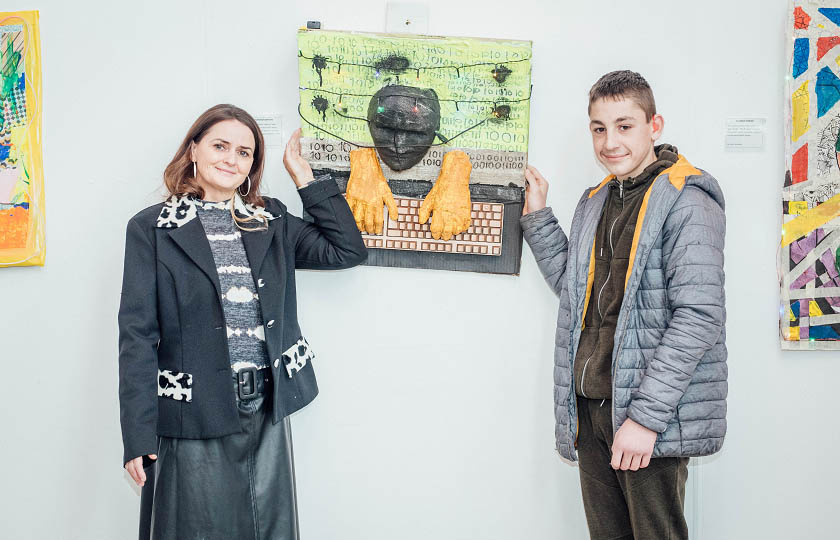 Artist, Shiela Richardson pictured with St. Canice's student and his artwork at the exhibition launch.