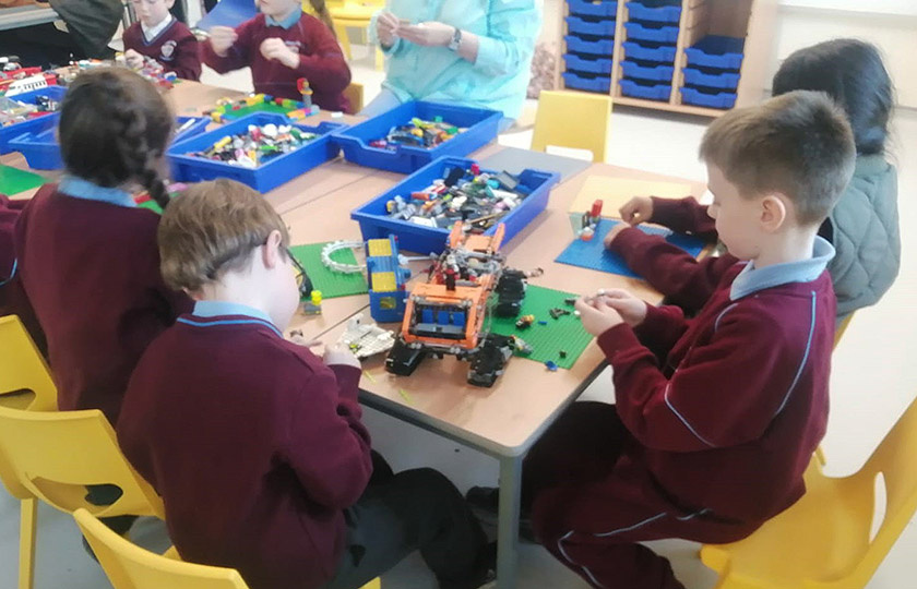 Children playing with LEGO in school setting.